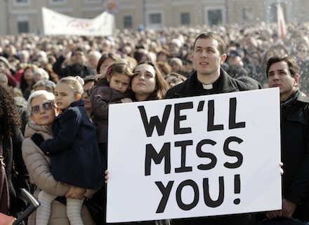 A priest holds a placard in St Peter's Square during yesterday's Angelus (AP)