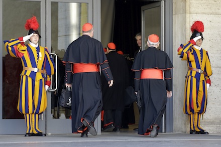 Guards salute as cardinals arrive for the first General Congregation meeting (AP)