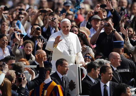 Pope Francis is driven through the crowd at his first general audience (AP)