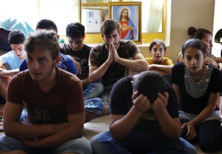 Displaced Iraqi Christians pray at a refugee camp in Irbil (Photo: CNS)